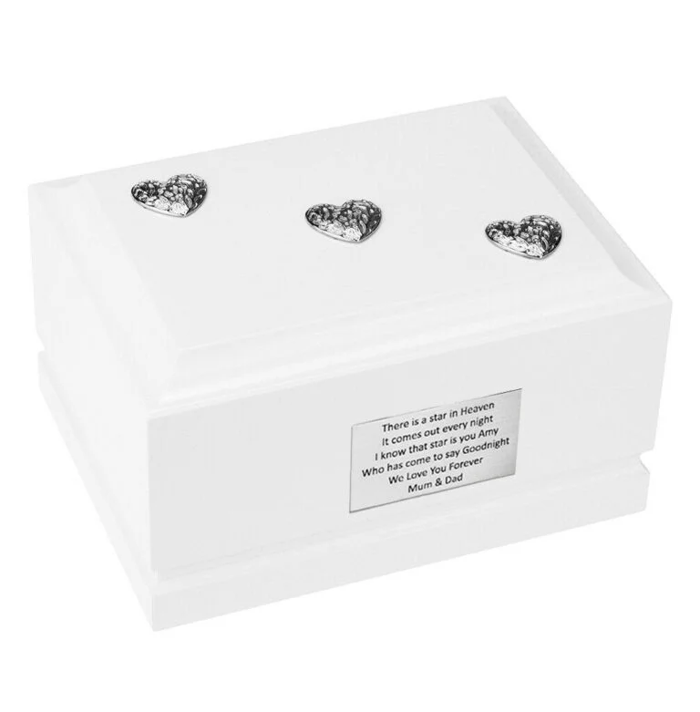 White wooden cremation urn for a child decorated with three silver hearts