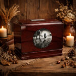 Wooden cremation urn for a mother with engraved silhouette scene, surrounded by candles and rustic décor.