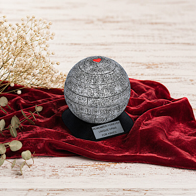 Mini urna decorativa esposta su tessuto rosso con accenti floreali