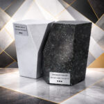 Modern geometric cremation urns in white and dark stone finish with textured surfaces, displayed on a stylish abstract background.
