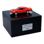 Schwarze Holzurne mit rotem Dodge-Modell – Ansicht von vorn (schräg).