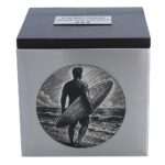 Vorderansicht einer Surfer-Gedenkurne mit eingraviertem Surfbrett und Meeresmotiv auf Edelstahl, Holzdeckel.