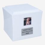 White wooden cremation urn with photo and memorial plaque