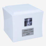 Angled view of white wooden cremation urn