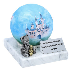 Blue spherical child urn with hand-painted castle on marble base and teddy bear figurine.