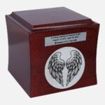 Wooden cremation urn with angel wings engraving and personalized nameplate, angled view.