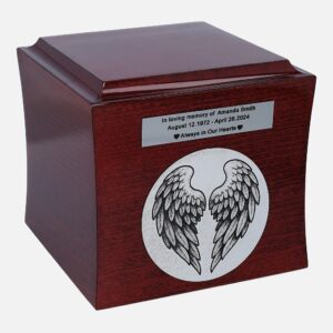 Wooden cremation urn with angel wings engraving and personalized nameplate, angled view.