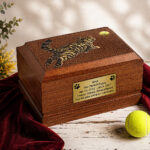 Urna funeraria de madera para gatos con diseño de gato jugando expuesta en un entorno conmemorativo Urna funeraria de madera para gatos <br/>