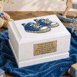 White Wooden Child Cremation Urn with Blue Baby Shoes Displayed in a Peaceful Memorial Setting