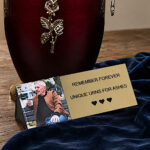 Personalized gold memorial plaque with photo displayed beside cremation urn