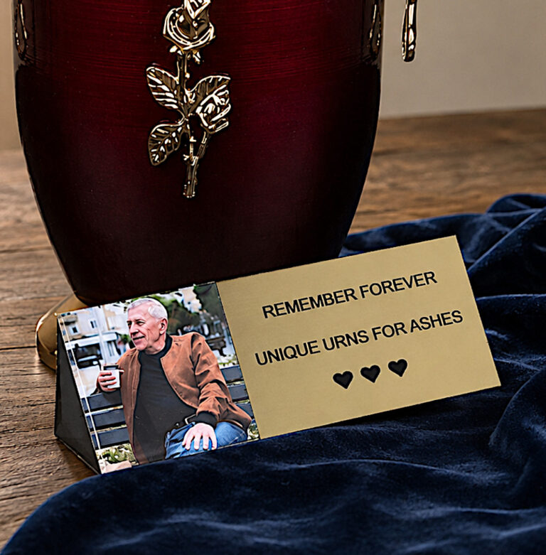 Personalized gold memorial plaque with photo displayed beside cremation urn