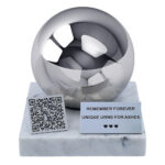 Front view of a pet urn with QR code, polished sphere, marble base and personalised memorial plaque.